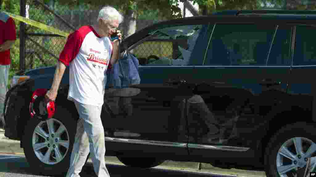 L'élu Jack Bergman, parle au téléphone en passant devant une voiture endommagé après des tirs, le 14 juin 2017, à Alexandria.