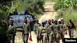 Des soldats congolais patrouillent dans le village abandonné de Kaswara, à 60 km au sud-ouest de Bunia, dans la région de l'Ituri, dans l'est de la République démocratique du Congo, le 14 juillet 2006.