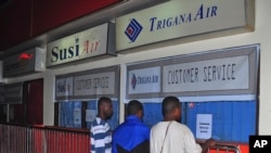 Relatives of passengers on the missing Trigana Air Service flight stand in front of its closed offices at Sentani airport in Jayapura, Papua province, Indonesia, Sunday, Aug. 16, 2015.