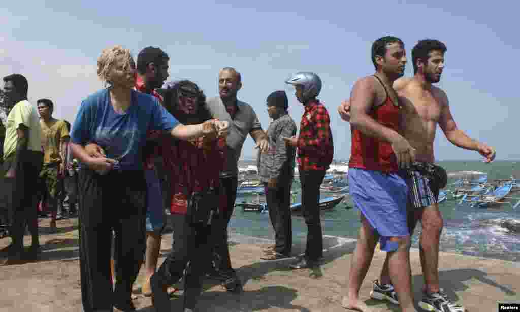 Para pencari suaka yang menumpang kapal yang terbalik setelah menghantam karang di Pantai Jayanti, dekat Cianjur, Jawa Barat (24/7).