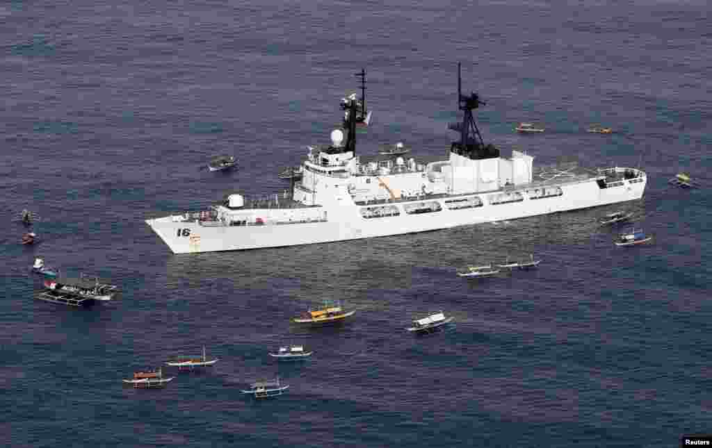 Philippine fishermen and a navy patrol gun boat welcome the arrival of BRP Ramon Alcaraz in the Casiguran Sea, northeastern Philippines, August 2, 2013.
