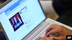 FILE - A user watches President Barack Obama speak via Facebook, June 4, 2009.