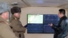 Pemimpin Korea Utara Kim Jong-un (kanan) berbicara dengan pejabat militer selama pengamatan terhadap apa yang dikatakan media pemerintah sebagai uji tembak rudal hipersonik di sebuah lokasi yang dirahasiakan di Korea Utara (12/1). (KCNA via KNS/AFP)