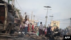 People gather at the scene of twin car bombs that exploded within moments of each other in the Somali capital, Mogadishu, Nov. 9, 2018, near the popular Sahafi Hotel.