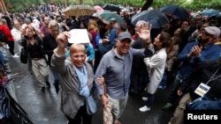 Voters are applauded as they leave a polling station for the banned independence referendum in Barcelona, Spain, Oct. 1, 2017. 