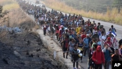 ARCHIVO - Migrantes caminan por la carretera a través de Arriaga, estado de Chiapas, en el sur de México, el 8 de enero de 2024, durante su viaje hacia la frontera con Estados Unidos.