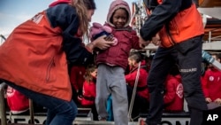 Seorang bocah migran yang diselamatkan dari Laut Mediterania, dibantu oleh petugas bantuan dari LSM Proactiva Open Arms, turun dari kapal di pelabuhan Crinavis, Algeciras, Spanyol, 28 Desember 2018.