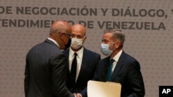 El presidente de la Asamblea Nacional de Venezuela, Jorge Rodríguez, a la izquierda, le da la mano al delegado de la oposición venezolana, Gerardo Blyde, en Ciudad de México. Agosto 13, 2021.