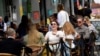 FILE - People relax at outdoor dining areas on the South Bank, as lockdown restrictions continue to ease amid the spread of the coronavirus disease, in London, May 28, 2021. 