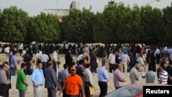 Egyptian nationals living in Kuwait stand in line at the entrance of the Egyptian Embassy before voting in Egypt's presidential elections, in Bnaid al-Gar, Kuwait, May 16, 2012.