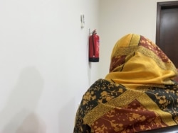 An evacuated Afghan woman, concealing her identity over concerns for family safety in Afghanistan, speaks during an interview with Reuters at a residential compound in Doha, Qatar, Aug. 21, 2021.