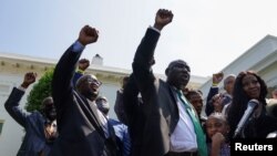 Familiares de George Floyd, encabezados por el abogado Ben Crump, levantan el puño en señal de protesta frente a la Casa Blanca, el 25 de mayo de 2021.