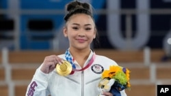 La medallista de oro Sunisa Lee de los Estados Unidos muestra su medalla para la gimnasia artística femenina en los Juegos Olímpicos de Verano de 2020, el jueves 29 de julio de 2021 en Tokio. (Foto AP / Gregory Bull)