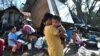 Des habitants se rassemblent près de leur maison détruite à Carcar, aux Philippines, le 18 décembre 2021, quelques jours après la chute du typhon Rai.