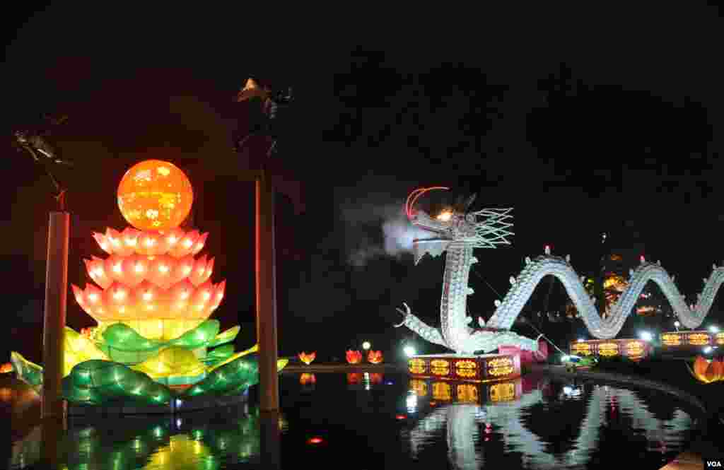 Giant smoke-belching dragons made of thousands of plates, cups and spoons, fight over a giant, silken pearl between them. (V. LaCapra/VOA)