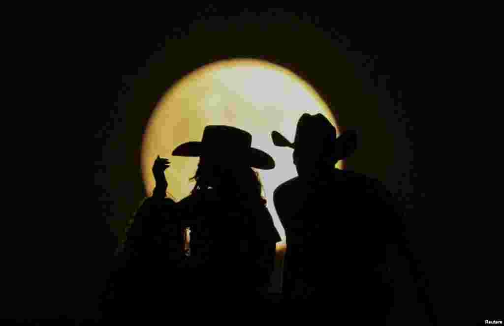 Espectadores observan la luna llena durante el eclipse lunar en las Dunas de Samalayuca, en las afueras de Ciudad Juárez, México, el 17 de septiembre de 2024. 
