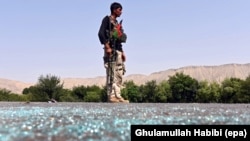 Tentara Afghanistan berjaga-jaga dalam bentrokan antara militan Negara Islam (ISIS) di distrik Kot, provinsi Nangarhar (26/6). (EPA/Ghulamullah Habibi)