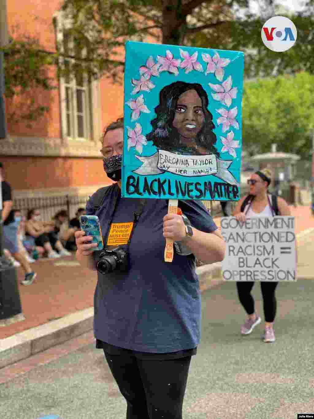 Las vidas negras importan y el racismo sancionado por el gobierno es igual a la opresión de los negros, dicen los carteles de dos manifestantes en Washington D.C. el sábado 6 de junio de 2020.
