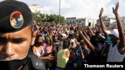 La gente reacciona durante las protestas contra y en apoyo del gobierno, en La Habana, Cuba, el domingo 11 de julio de 2021.