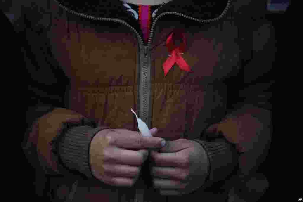 Seorang perempuan Nepal dari "Maiti Nepal", pusat rehabilitasi untuk korban perdagangan seks, menyalakan lilin pada malam Hari AIDS Sedunia di Kathmandu (30/11). (AP/Niranjan Shrestha) 