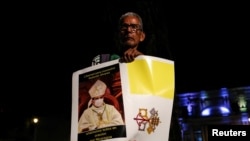 Un exiliado nicaragüense en Costa Rica sostiene un cartel con una bandera de la Ciudad del Vaticano para protestar contra la detención de Rolando Álvarez en Costa Rica. REUTERS/Mayela López
