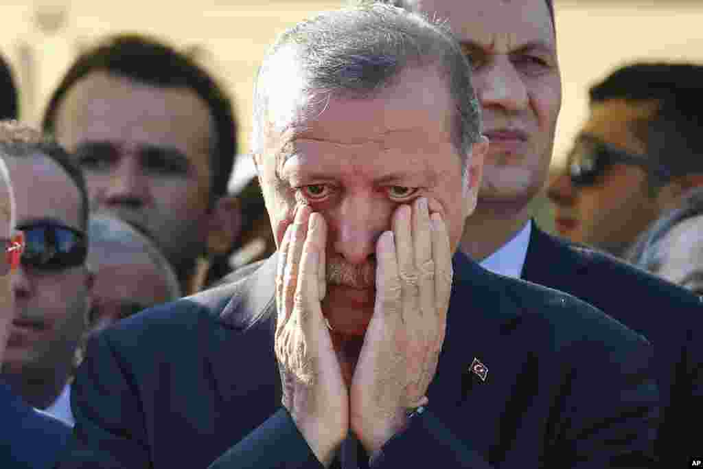 Turkish President Recep Tayyip Erdogan right, wipes his tears during the funeral of Mustafa Cambaz, Erol and Abdullah Olcak, killed Friday while protesting the attempted coup against Turkey's government, in Istanbul, July 17, 2016.
