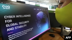 FILE - A woman checks the website of Israel-made Pegasus spyware at an office in the Cypriot capital Nicosia on July 21, 2021. Israel-made Pegasus spyware was used to monitor activists, journalists and politicians around the world.