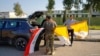 Voluntarios sostienen banderas iraquíes y vaticanas mientras decoran las calles de cara a la visita del Papa Francisco, en Qaraqosh, Iraq, el 22 de febrero del 2021.
