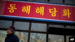 FILE - A man walks past a branch of the North Korean-operated Haedanghwa restaurant in Beijing.