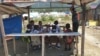 Sekelompok anak-anak pelajar sekolah dasar yang berteduh pada salah satu bangunan kayu seusai pulang sekolah di kawasan pengungsian Balaroa, Palu Barat, Sulawesi Tengah, 22 Juli 2019. (Foto: Yoanes Litha/VOA)