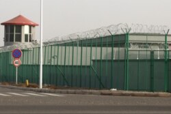 FILE - A guard tower and barbed wire fence surround a detention facility in the Kunshan Industrial Park in Artux in western China's Xinjiang region, Dec. 3, 2018.