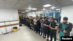 People pray next to the dead bodies of Palestinians at Kamal Adwan Hospital, during the Israeli military operation, amid Israel-Hamas conflict, in Beit Lahiya, in the northern Gaza Strip, Dec. 17, 2024.