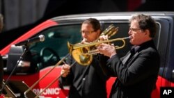 Miembros de la Filarmónica de Nueva York interpretan música durante un concierto al aire libre, en un primer paso de retorno a la normalidad.