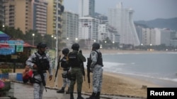 Agentes federales mexicanos observan la playa de Acapulco, México, antes de la llegada del huracán Otis el 24 de octubre de 2023. 