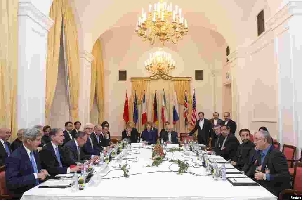Delegations of U.S. Secretary of State John Kerry, Britain's Foreign Secretary Philip Hammond, Russian Foreign Minister Sergei Lavrov, German Foreign Minister Frank-Walter Steinmeier, French Foreign Minister Laurent Fabius, Chinese Foreign Minister Wang Yi, EU High Representative Catherine Ashton, and Iranian Foreign Minister Javad Zarif sit around the negotiations table during their meeting in Vienna, Nov. 24, 2014.