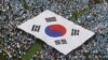 FILE - Orang-orang membawa bendera nasional Korea Selatan saat unjuk rasa anti-Korea Utara di Seoul, 6 Juni 2011. Pusat Penanggulangan Terorisme Nasional Korea Selatan menaikkan tingkat pengawasan teror negara itu ke status 'waspada', 2 Mei 2024.