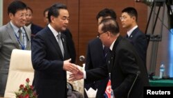 왕이 중국 외교부장(왼쪽)과 리수용 북한 외무상이 지난 2014년 8월 미얀마에서 열린 아세안지역안보포럼(ARF)에서 만나 악수하고 있다. (자료사진)