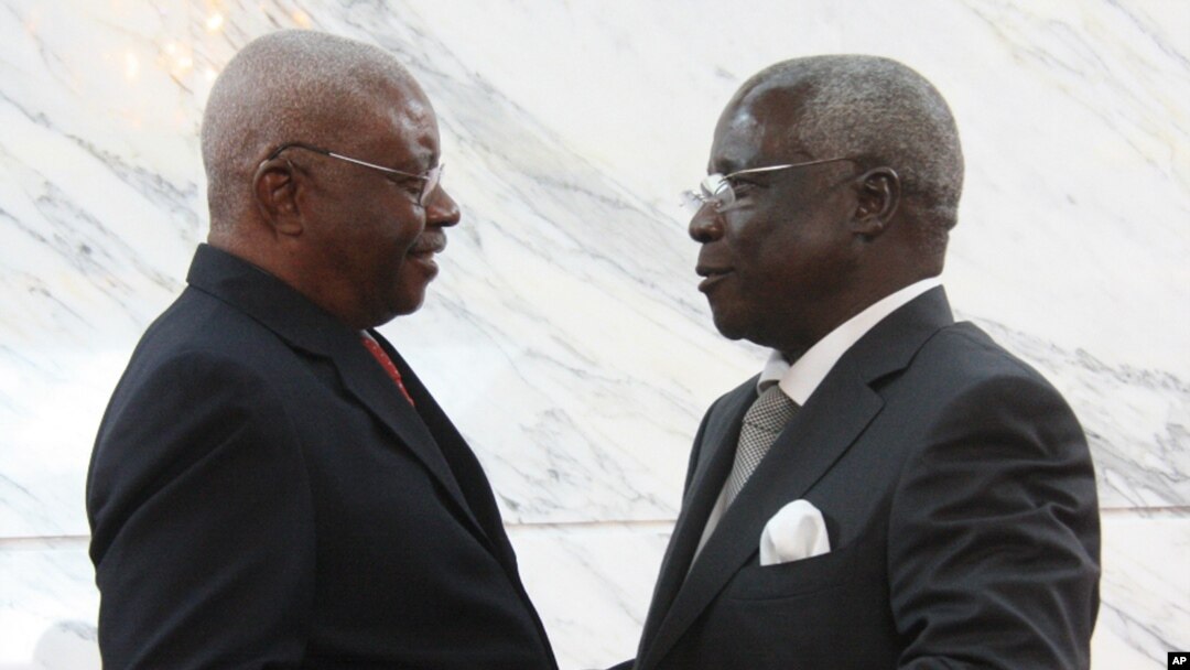 Mozambique President Arnando Guebuza, left, and former Renamo rebel leader Afonso Dhlakama, right, shake hands after signing a peace accord, Sept. 5, 2014. 