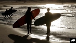 FILE - Surfers prepare to enter the water at Bondi beach near Sydney, Australia on April 28, 2020. (AP Photo/Rick Rycroft)