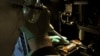 FILE - A researcher injects DNA material onto a laboratory dish.