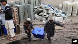 Petugas pemilu Afghanistan membawa kotak suara di Jalalabad, Kabul timur, Afghanistan, Minggu, 6 April 2014.
