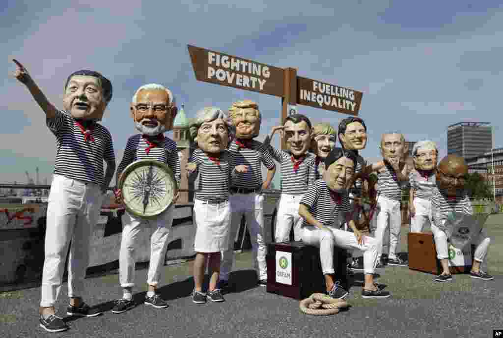 Oxfam stages a protest demanding less poverty and less inequality from the G-20 summit by having people dressed as assorted global leaders, from left, Chinese President Xi Jinping, Indian Prime Minister Narendra Modi, British Prime Minister Theresa May, U.S. President Donald Trump, Japanese Prime Minister Shinzo Abe, France's President Emmanuel Macron, German Chancellor Angela Merkel, Canada's Prime Minister Justin Trudeau, Russian President Vladimir Putin, Italian Prime Minister Paolo Gentiloni and South African President Jacob Zuma in Hamburg, Germany.