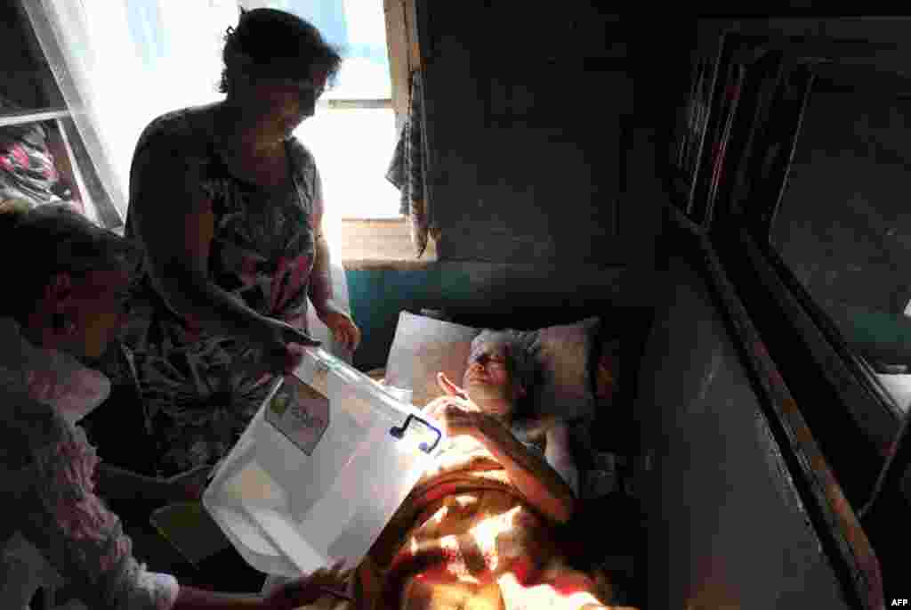 An elderly woman casts her ballot at her home in the village of Sartichala in Georgia's Kakhety region, October 1, 2012.
