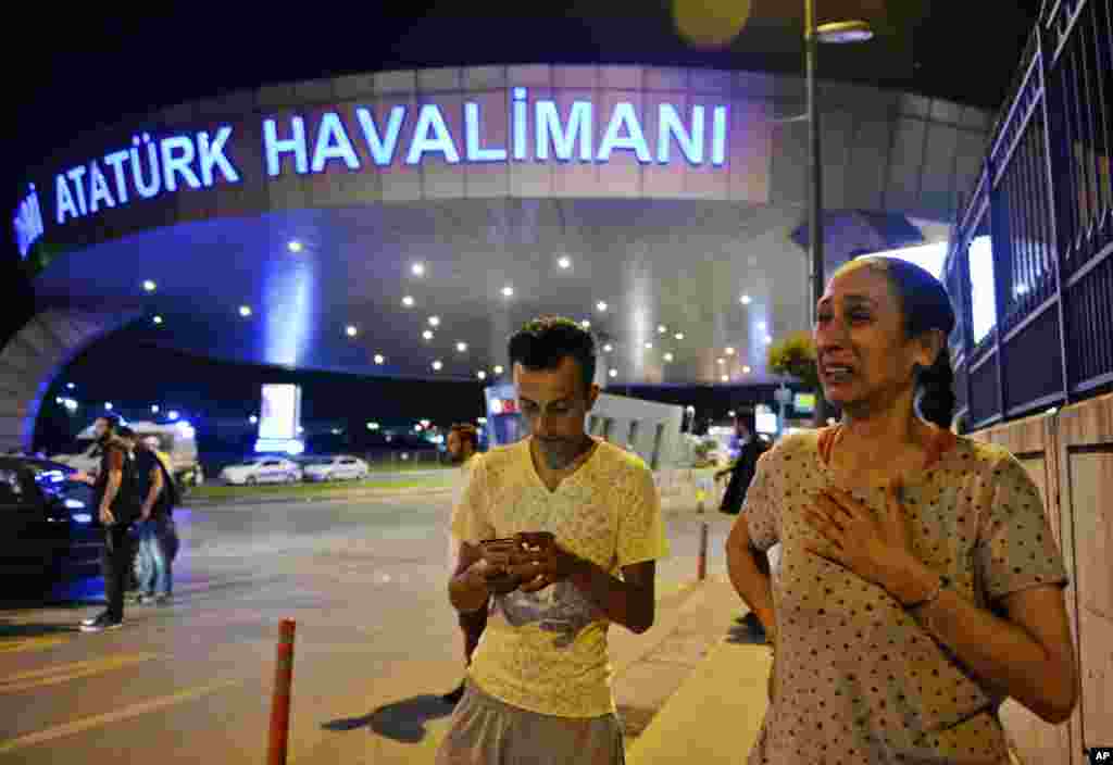 People gather at the entrance to Istanbul's Ataturk airport in the early-morning hours of June 29, 2016, after suicide bombers struck in the terminal, killing dozens of people and wounding many others.