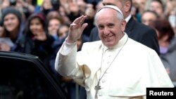 Pope Francis waves as he leaves at the end of his mass at the Church of the Most Holy Name of Jesus in Rome, Jan. 3, 2014. 