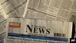 FILE - Pages of the The Gardner News are seen in an illustration photo in Gardner, Kansas, Dec. 20, 2019. A steep drop in advertising revenue has forced many local papers in the U.S. to make significants cuts or close altogether.