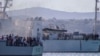 FILE - Migrants arrive in Porto Empedocle, Sicily, aboard two military ships after being transferred from the island of Lampedusa, where a number of small boats carrying migrants arrived a few days earlier, July 27, 2020. 
