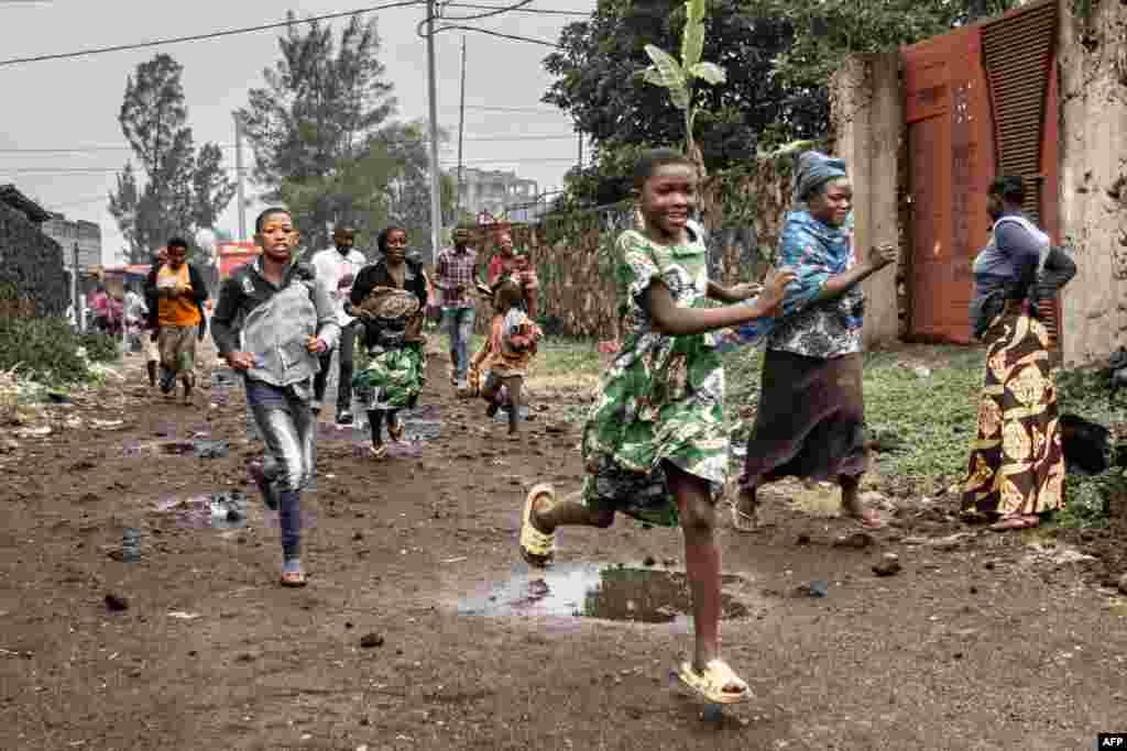Residents run off after observing members of the M23 armed group walking through a street of the Keshero neighborhood in Goma, Jan. 27, 2025. The besieged city of Goma was rocked by heavy artillery fire as France warned the regional capital was on the brink of falling to militia fighters and Rwandan troops. The M23 armed group and Rwandan soldiers entered Goma's centre on the night of Jan. 26, 2025 after weeks of advancing on the main city in the mineral-rich North Kivu province.
