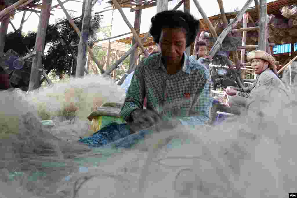 ស្រ្តីម្នាក់កំពុងដេរសំណាញ់ត្រី នៅក្នុងភូមិកំពង់ភ្លុក ខេត្តសៀមរាប កាលពីថ្ងៃទី៥ ខែធ្នូ ឆ្នាំ២០១៥។ (នូវ ពៅលក្ខិណា/VOA)