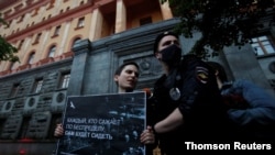 Ruski policajac privodi učesniga stojećeg protesta u znak podrške novinarki Svetlani Prokopjevoj, u Moskvi, 3. jula 2020.